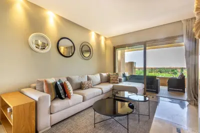 a living room with a couch and a table at Stylish In Prestigia Area Pool View in Marrakech