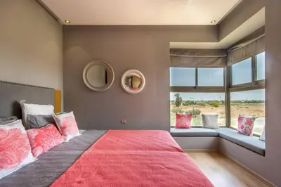 a bedroom with a large bed with a red blanket at Stylish In Prestigia Area Pool View in Marrakech