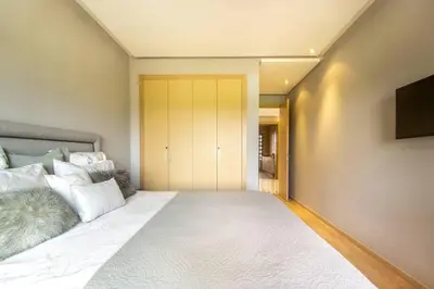 a bedroom with a large white bed and a television at Stylish In Prestigia Area Pool View in Marrakech