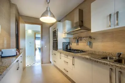 a large kitchen with white cabinets and a sink at Stylish In Prestigia Area Pool View in Marrakech