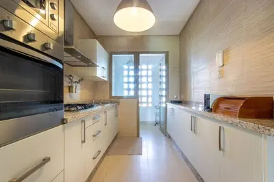 a large kitchen with white cabinets and a large window at Stylish In Prestigia Area Pool View in Marrakech