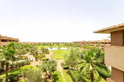 a view of a park with palm trees and buildings at Stylish In Prestigia Area Pool View in Marrakech