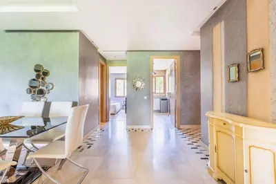 a dining room and living room with a dining table and chairs at Front de piscine en rez de Jardin a Prestigia in Marrakech