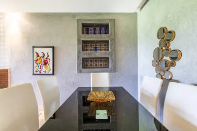 a dining room with a black table and white chairs at Front de piscine en rez de Jardin a Prestigia in Marrakech