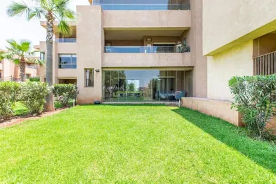 a house with a lawn in front of it at Front de piscine en rez de Jardin a Prestigia in Marrakech