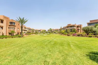 a large yard in front of a resort at Front de piscine en rez de Jardin a Prestigia in Marrakech