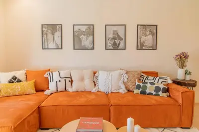 a living room with an orange couch with pillows on it at Wonderfull Place in Marrakech - Pool Wifi Terrace in Marrakech
