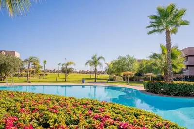a swimming pool in a park with palm trees and flowers at Wonderfull Place in Marrakech - Pool Wifi Terrace in Marrakech