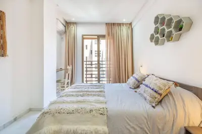 a bedroom with a large bed with white walls at Cosy Appt au Coeur de Gueliz in Marrakech