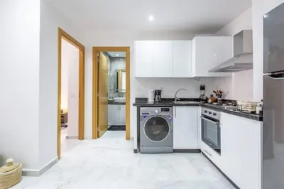 a kitchen with white cabinets and a dishwasher at Cosy Appt au Coeur de Gueliz in Marrakech