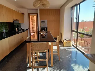 a kitchen with a table and chairs in a room at Villa Sissi Marrakech in El Rhechat