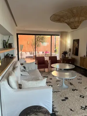 a living room with a white couch and a table at Villa Sissi Marrakech in El Rhechat