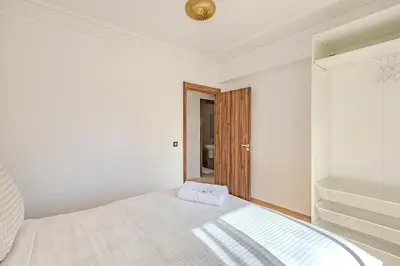 a white bedroom with a bed and a window at New! appt Nour Confort avec piscine & wifi in Marrakech