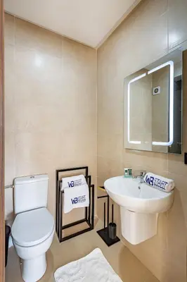 a bathroom with a white toilet and a sink at New! appt Nour Confort avec piscine & wifi in Marrakech