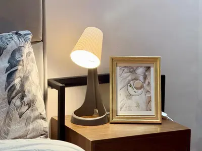 a lamp and a picture on a night stand next to a bed at Ruby in Marrakech