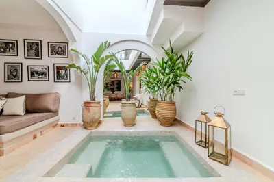 a living room with a swimming pool and plants at Riad Dar Jamila Breakfast 10mn to Jamaa Al Fna in Marrakech