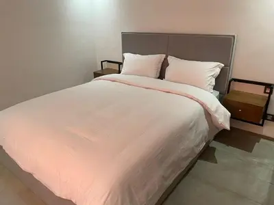 a large bed with white sheets and pillows at La perle in Marrakech