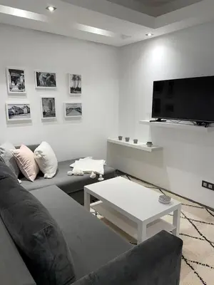 a living room with a couch and a flat screen tv at La perle in Marrakech