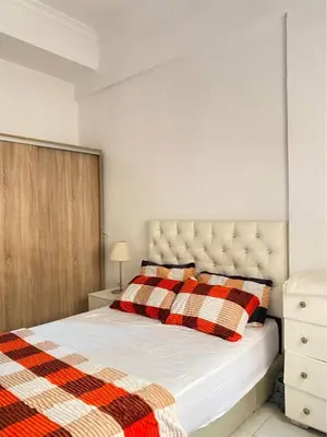a bedroom with a bed with a checkered blanket at Apparetement 2 chambres in Marrakech