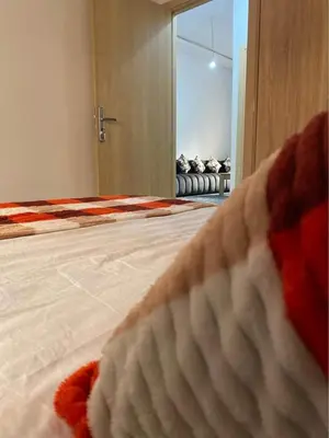 a bedroom with a bed and a window with a couch at Apparetement 2 chambres in Marrakech