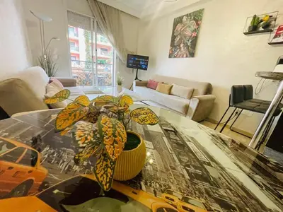 a living room with a table with a plant on it at Apparetement 2 chambres in Marrakech