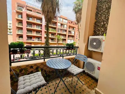a balcony with a table and chairs and a building at Apparetement 2 chambres in Marrakech
