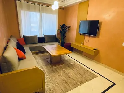 a living room with a couch and a flat screen tv at Gueliz center with pool and parking in Marrakech