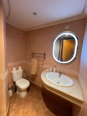 a bathroom with a sink and a toilet and a mirror at Gueliz center with pool and parking in Marrakech