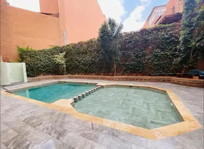 a swimming pool in the middle of a building at Gueliz center with pool and parking in Marrakech