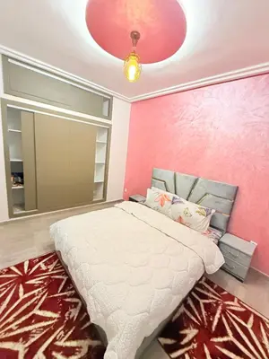 a bedroom with a bed with a pink wall at Appartement Calme Parfait & Centre-ville in Marrakech
