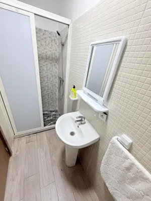 a white bathroom with a sink and a shower at Appartement Calme Parfait & Centre-ville in Marrakech