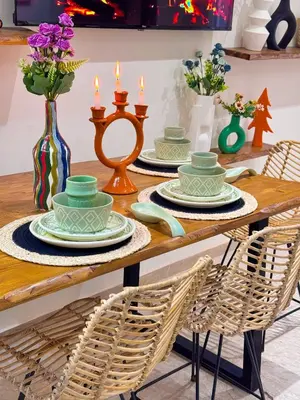 a wooden table with plates and candles on it at Appartement luxe au cœur de Marrakech in Marrakech