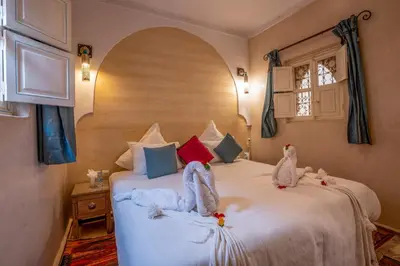 two stuffed animals sitting on a bed in a bedroom at Dar Flora in Marrakech