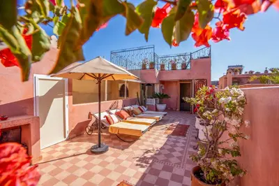 a patio with a couch and an umbrella at Dar Flora in Marrakech