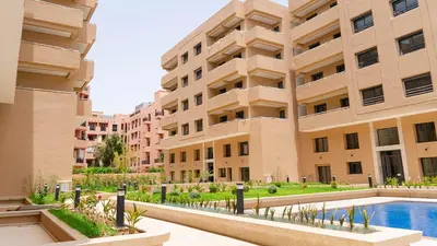 an apartment building with a swimming pool in front of it at Luxury Family Duplex in the Best Area of Marrakech with Pool and Garden in Marrakech