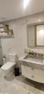 a bathroom with a toilet and a sink and a mirror at Luxury Family Duplex in the Best Area of Marrakech with Pool and Garden in Marrakech