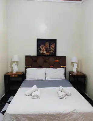 a bedroom with a bed with two towels on it at APPARTEMENT DAR MARRAKECh G27 N7 in Marrakech