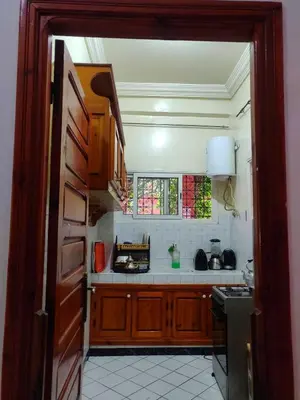 a kitchen with a door open to a kitchen with a stove at APPARTEMENT DAR MARRAKECh G27 N7 in Marrakech