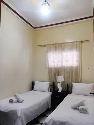 two beds in a room with a window at APPARTEMENT DAR MARRAKECh G27 N7 in Marrakech