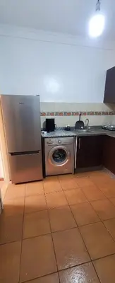 a kitchen with a refrigerator and a washing machine at Well-equipped apartment for rent in Marrakech