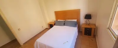a small bedroom with a white bed with blue pillows at Well-equipped apartment for rent in Marrakech