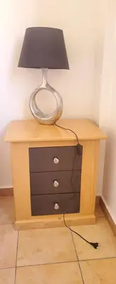 a table with a lamp on top of a dresser at Well-equipped apartment for rent in Marrakech