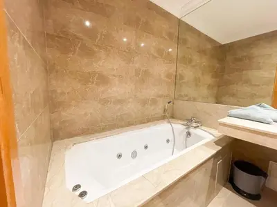 a bathroom with a bath tub and a sink at appartement luxueuse in Marrakech