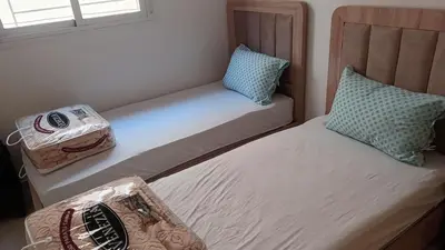a pair of beds in a small bedroom at marrakech mountazah al jadid in Marrakech