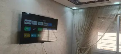 a flat screen tv on a wall with a window at marrakech mountazah al jadid in Marrakech