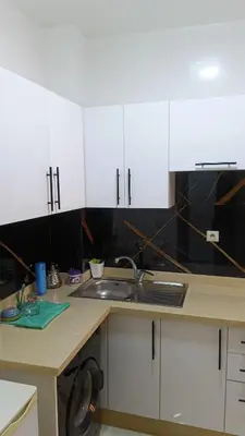 a kitchen with white cabinets and a sink at marrakech mountazah al jadid in Marrakech