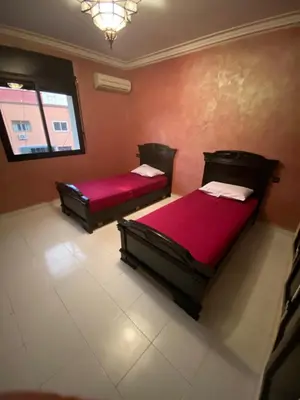 two beds in a room with red walls at Marrakech gliz in Marrakech