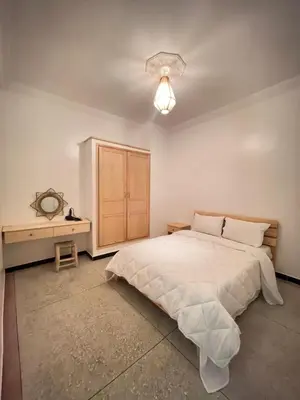 a bedroom with a large bed and a dresser at Modern et calme a Marrakech in Marrakech