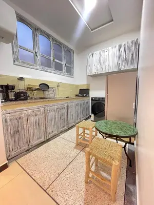 a kitchen with a table and chairs in a room at Modern et calme a Marrakech in Marrakech