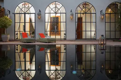 a building with a reflection in a pool of water at Daba Riads in Marrakech